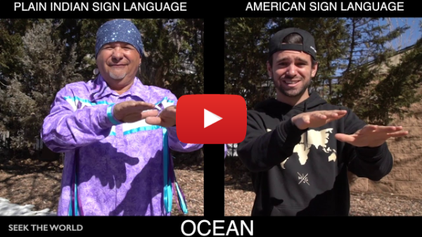 A YouTube still of two men showing off two different signs for ocean in ASL and Indian Sign Language. The text below says, “Ocean” as well as “Seek The World” at the bottom left.