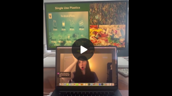 DEAF, Inc. Advocate, Nicole Dergosits, a white woman with long dark hair, wearing a black top with a white wall behind her and a door on her right. Her video is on a laptop with a monitor behind the laptop showing three images of "Single Use Plastics" which is green with white text and the other 2 images on the right are of plastic dumped on the earth.